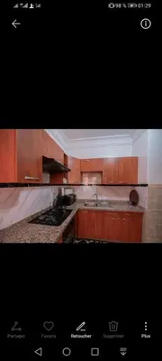 a kitchen with wooden cabinets and a stove top oven at pation et jardin in Marrakech