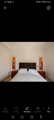 a picture of a bedroom with a bed with two tables at pation et jardin in Marrakech