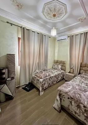 a bedroom with two beds and a chandelier at Appartement Jamaa El Fna View in Marrakech