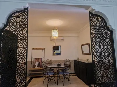 a dining room with a table and chairs at Appartement 2 chambres, piscine, vue palmeraie in Marrakech