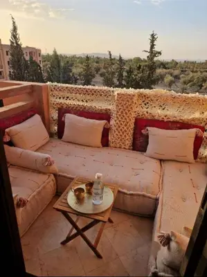 a living room with a couch and a table at Appartement 2 chambres, piscine, vue palmeraie in Marrakech