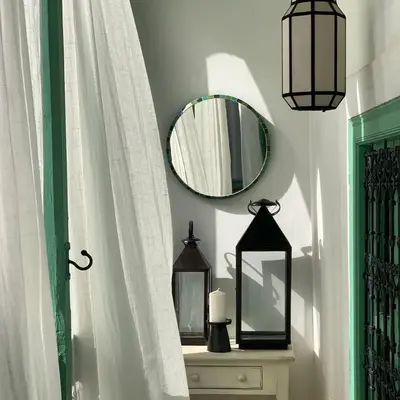 a bathroom with a mirror and a dresser with a sink at Riad dar Maloukti in Marrakech