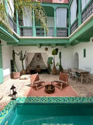 a living room with a swimming pool and a house at Riad dar Maloukti in Marrakech