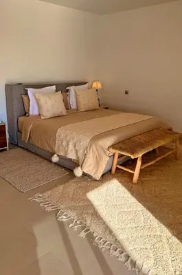 a bedroom with a large bed with a wooden table at CASA EDEN - Serenity and elegance between Atlas mountains and city center in Marrakech