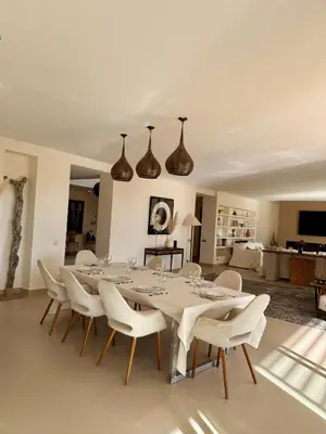 a dining room with a table and white chairs at CASA EDEN - Serenity and elegance between Atlas mountains and city center in Marrakech