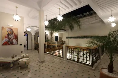 a lobby of a building with potted plants and chandeliers at riad NAMLA in Marrakech