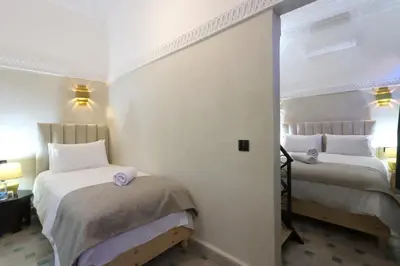 two beds in a room with white walls at riad NAMLA in Marrakech