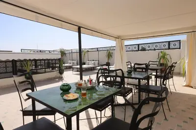 a patio with tables and chairs on a balcony at riad NAMLA in Marrakech