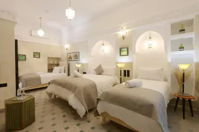 a hotel room with three beds in a room at riad NAMLA in Marrakech