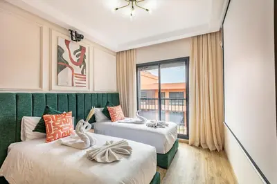 two beds in a room with a window at Prestigia GOLF with Pool Bohemian Cocoon Stylish in Marrakech