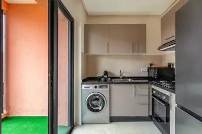 a kitchen with a washing machine and a sink at Prestigia GOLF with Pool Bohemian Cocoon Stylish in Marrakech