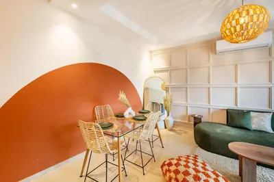 a living room with a table and chairs and a couch at Prestigia GOLF with Pool Bohemian Cocoon Stylish in Marrakech