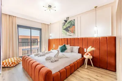 a large orange bed in a room with a window at Prestigia GOLF with Pool Bohemian Cocoon Stylish in Marrakech