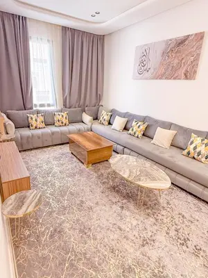 a living room with a couch and two tables at Studio haut standing in Marrakech