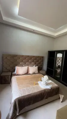 a bedroom with a large bed with a large headboard at villa BASMA in Marrakech
