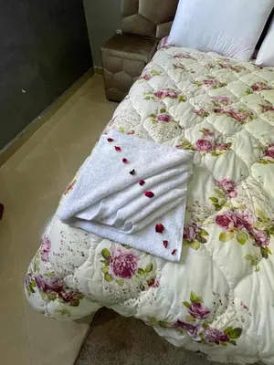 a bed with a white blanket with flowers on it at villa BASMA in Marrakech