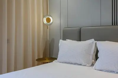 a bedroom with a bed with white pillows and a lamp at Your Tiny Paradise - Marrakech - Prestigia in Marrakech