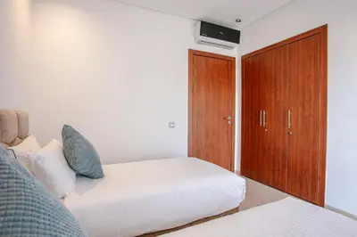 a bedroom with a bed and a wooden cabinet at The Art of Stay - Marrakech - Prestigia in Marrakech