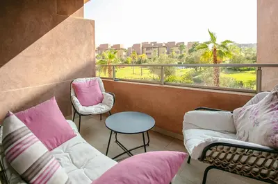 a balcony with a couch and chairs and a table at The Art of Stay - Marrakech - Prestigia in Marrakech