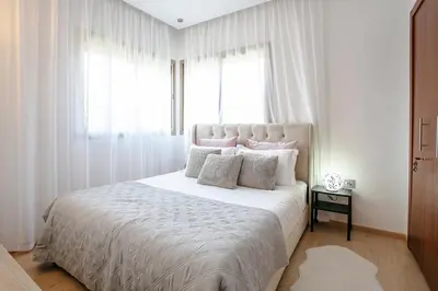 a bedroom with a white bed with pillows and a window at The Art of Stay - Marrakech - Prestigia in Marrakech