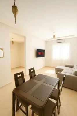 a living room with a table and a couch at Cosy appartement 75m2 in Marrakech