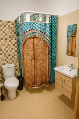 a bathroom with a toilet and a shower curtain at Cosy appartement 75m2 in Marrakech