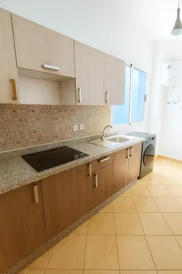 a kitchen with wooden cabinets and a sink at Cosy appartement 75m2 in Marrakech
