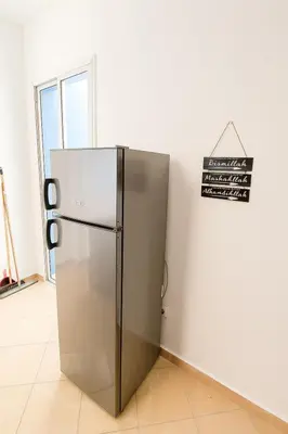 a silver refrigerator in a room with a sign on the wall at Cosy appartement 75m2 in Marrakech