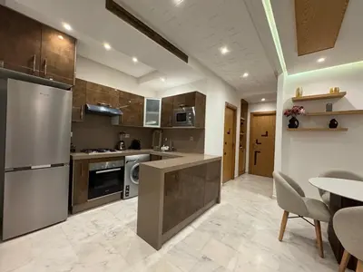 a kitchen with stainless steel appliances and a table at Chic 2BDR Apartment in Gueliz in Marrakech