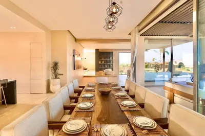 a dining room with a long wooden table and chairs at Villa youngLA in Sehib Foukani