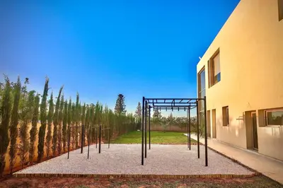 a playground in front of a building with trees at Villa youngLA in Sehib Foukani