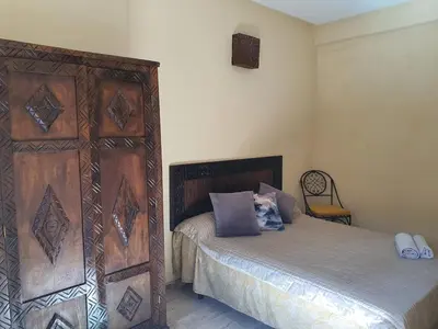 a bedroom with a bed and a wooden wall at Appartememt Hivernage 4 in Marrakech