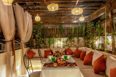a dining room with a table and chairs and plants at Riad Musee in Marrakech