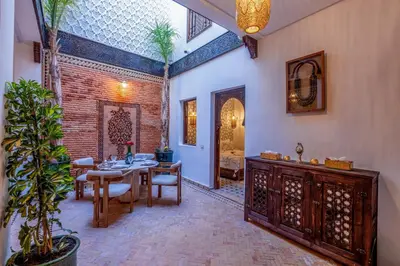 a dining room with a table and a brick wall at Riad Musee in Marrakech
