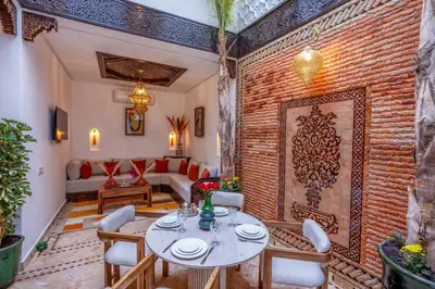 a room with a brick wall and a table and chairs at Riad Musee in Marrakech