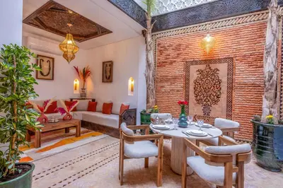 a living room with a table and chairs and a couch at Riad Musee in Marrakech