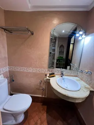 a bathroom with a sink and a toilet and a mirror at Studio Rolex Guéliz, situé à seulement 5 minutes de la place Jemaa El-Fna in Marrakech