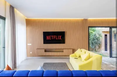 a living room with a yellow couch and a tv at Villa Atlas piscine chauffee sans vis a vis in Marrakech