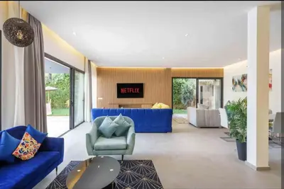 a living room with a blue couch and chairs at Villa Atlas piscine chauffee sans vis a vis in Marrakech
