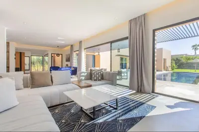 a living room with a white couch and a table at Villa Atlas piscine chauffee sans vis a vis in Marrakech