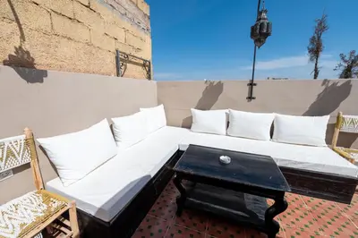 a couch and a coffee table on a balcony at Dar Tbib in Marrakech