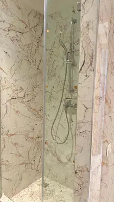 a shower in a bathroom with a marble wall at Honey home Marrakech in Marrakech