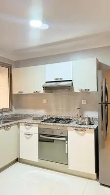 a kitchen with white cabinets and a stove top oven at Honey home Marrakech in Marrakech