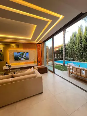 a living room with a couch and a tv on a wall at Villa Elixir , Luxury residence , private pool in El Rhechat