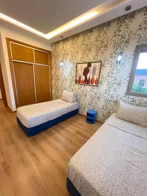 a room with two beds and a painting on the wall at Villa Elixir , Luxury residence , private pool in El Rhechat