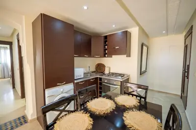 a kitchen with a table and chairs and a stove at Luxury 2 BDRM in Hivernage with Pool and Garden in Marrakech
