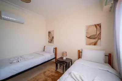 two beds in a room with white walls at Luxury 2 BDRM in Hivernage with Pool and Garden in Marrakech