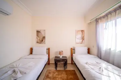 two beds in a room with a table and a window at Luxury 2 BDRM in Hivernage with Pool and Garden in Marrakech