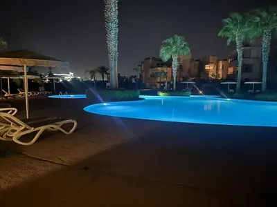a swimming pool at night with blue lights at Prestigia Pool 5 min Airport in Marrakech