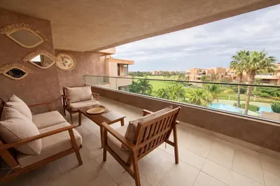 a room with a balcony with a view of a pool at Prestigia Pool 5 min Airport in Marrakech